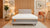 Bedroom with Emma Body Adapt all-foam mattress in the center, surrounded by lamps, a plant, and a chair.